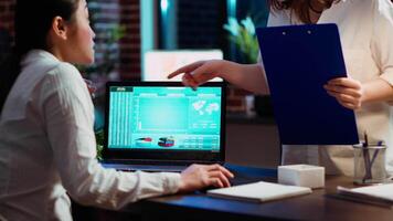 Manager and company financial advisor analyzing statistical graphs, zoom in shot on laptop screen. Management executive and worker comparing business revenue numbers in brick wall office, camera B video