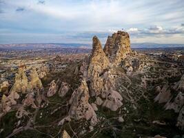 Aerial drone view of the Uchisar Castle in Cappadocia, Turkey during sunset. This tall volcanic-rock outcrop is one of Cappadocia's most prominent landmarks. photo