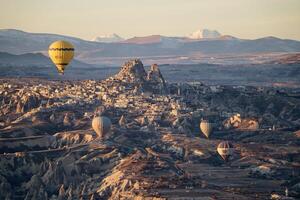 caliente aire globo vuelo en goreme en Turquía durante amanecer. paseo en un caliente aire globo, el más popular actividad en capadocia. romántico y famoso viaje destino. foto