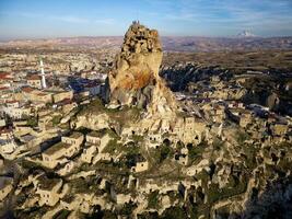 aéreo zumbido ver de el ortahisar castillo en capadocia, Turquía con el nieve tapado montar erciyes en el antecedentes. personas disfrutando el ver desde el parte superior de el castillo. foto