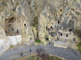 View of the Goreme Open Air Museum in Cappadocia, Turkey. This Unesco World Heritage site is an essential stop on any Cappadocian itinerary. Tourists visiting the historical site. photo