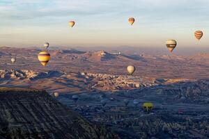 Hot air balloon flight in Goreme in Turkey during sunrise. Ride in a hot air balloon, the most popular activity in Cappadocia. Romantic and famous travel destination. photo