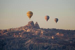 caliente aire globo vuelo en goreme en Turquía durante amanecer. paseo en un caliente aire globo, el más popular actividad en capadocia. romántico y famoso viaje destino. foto