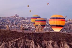 caliente aire globo vuelo en goreme en Turquía durante amanecer. paseo en un caliente aire globo, el más popular actividad en capadocia. romántico y famoso viaje destino. foto