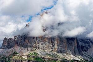 View of Tofane mountain range covered with clouds in the Dolomites, Italy. Amazing destination for trekkers and hikers. Famous mountaineering place. photo