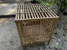 a small cage with a wooden top and bars photo