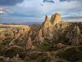 Aerial drone view of the Uchisar Castle in Cappadocia, Turkey during sunset. This tall volcanic-rock outcrop is one of Cappadocia's most prominent landmarks. photo