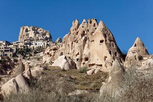 View of Uchisar Castle in Cappadocia, Turkey and several old troglodyte settlements. Uchisar Castle is a tall volcanic-rock outcrop and is one of Cappadocia's most prominent landmarks. photo