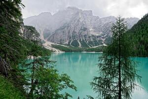 View over Lake Braies or Pragser Wildsee in the Dolomites, one of the most beautiful lakes in Italy. Boats in the middle of the lake surrounded by mountains. Travel and leisure. photo