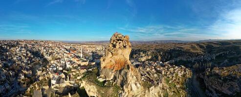 aéreo zumbido ver de el ortahisar castillo en capadocia, Turquía con el nieve tapado montar erciyes en el antecedentes. personas disfrutando el ver desde el parte superior de el castillo. foto