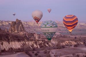 caliente aire globo vuelo en goreme en Turquía durante amanecer. paseo en un caliente aire globo, el más popular actividad en capadocia. romántico y famoso viaje destino. foto