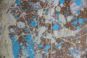 Abstract spots, drops of yellow blue white paint on a brown wooden surface photo