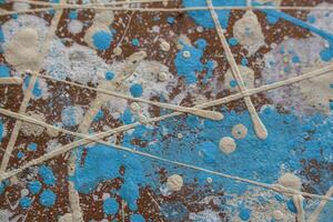 Abstract spots, drops of yellow blue white paint on a brown wooden surface photo