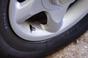 Close-up of a black car tire on dirt road. photo