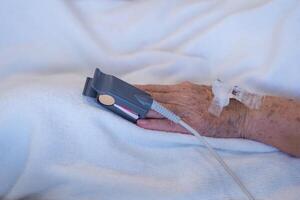 Close-up of blood oxygen oximeter and heart rate from a elderly patient fingertip in room at the hospital. Health care concept photo