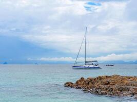 Seascape beautiful of bright blue sea surface with floating white yacht photo