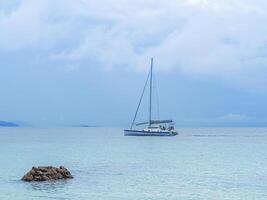 Seascape beautiful of bright blue sea surface with floating white yacht photo