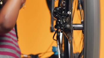 Close up shot of bike wheel being tested by repairman doing servicing. Focus on bicycle tires being fixed by professional in blurry background checking for faults in break rotor video