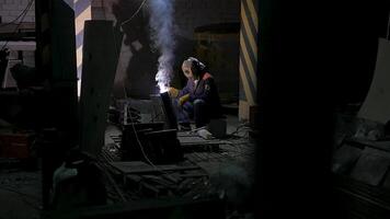 Worker with protective mask welding metal.welding in black background in slow motion. Man with protective mask welding metal in dark contrast background in slow motion video