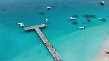 Antenne Aussicht von Paradies Malediven tropisch Strand mit Seebrücke und Geschwindigkeit Boote auf Insel. Sommer- und Reise Ferien Konzept. video