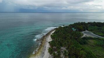 Aerial view of ocean with waves and coastline on Fuvahmulah island in Maldives video