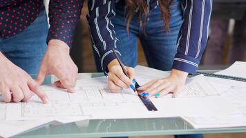 Close up hands of female designer drawing on blueprints. Architect working on building development. video