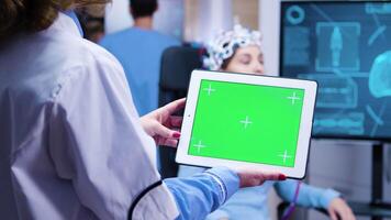 vrouw dokter op zoek Bij tablet met groen scherm in een modern faciliteit voor neurologie wetenschap. video