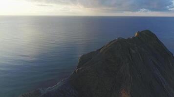 aéreo Visão sobre a campo e chileno litoral em nublado azul céu e mar fundo. tomada. surpreendente panorama dominado de a mar, a Fazenda Campos e pedras ao longo a costa. video