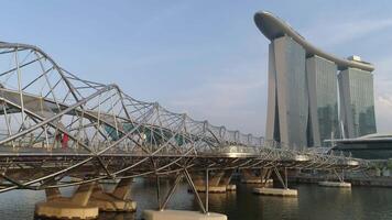 Singapore - June 28, 2018 . Concrete covered with stainless bridge to Marina Bay Sands Hotel in a cloudy day in Singapore. Singapore city in the daytime. The Helix Bridge and Marina Bay Sand in video