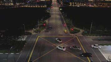 nacht verkeer beweging Bij de centrum van groot stad, antenne stedelijk visie. schot. antenne visie van nacht weg met in beweging auto's en mooi gebouwen. video