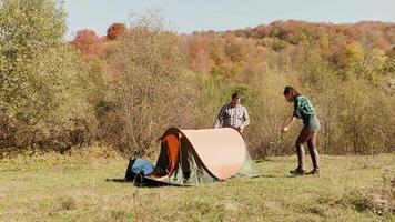 Beautiful young couple helping each other setting up the camping tent. Couple teamwork. video