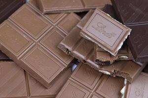 KYIV, UKRAINE - MAY 4, 2022 Lindt Swiss luxury brand chocolate brown tablets with embossed logo photo