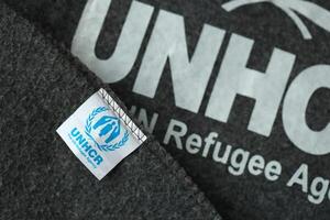 Kyiv, ucrania - 4 de mayo de 2022 acnur el logotipo de la agencia de refugiados de la onu en mantas grises humanitarias foto