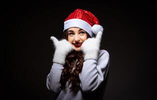 un mujer vistiendo un Papa Noel sombrero y guantes foto