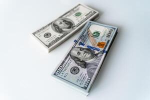 Stacks of One Hundred Dollar Bills on a White Surface. Two stacks of one hundred dollar bills on a white surface photo