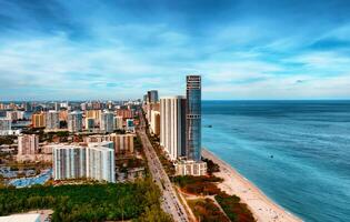 aéreo ver de Miami ciudad y océano, cautivador paisaje urbano anidado junto a vasto Oceano aguas foto