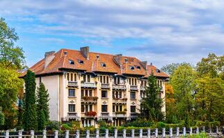 Majestic Building With Basketball Court in Brasov, Romania. A magnificent building in Brasov, Romania, featuring a basketball court in front. photo