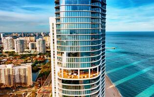 A stunning aerial view capturing a high rise building perfectly positioned next to the beautiful ocean in Miami, USA. photo