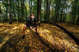 un hombre en un negro traje ejecutando un magia truco en el encantado bosque. un hombre en un negro traje es haciendo un truco en el bosque foto