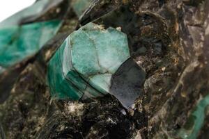 Macro emerald stone mineral in rock on white background photo