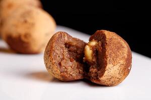 Beautiful candy truffle with a nut inside on a white plate on a black background photo