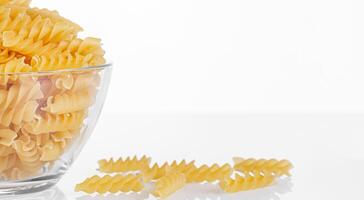 Pasta products in the form of a spiral on a plate, texture, on a white background photo