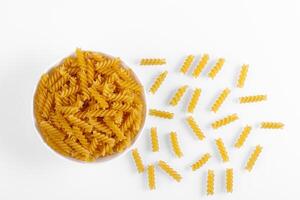 Pasta products in the form of a spiral on a plate, texture, on a white background photo