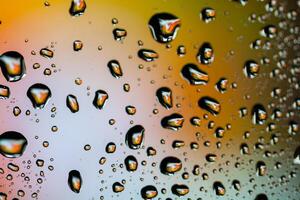 hermosas gotas de agua multicolores en un vaso foto