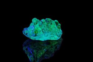 macro mineral stone opal under ultraviolet light on a black background photo