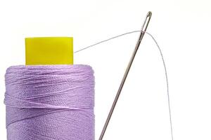 Macro skein of thread purple colors with a needle on a white background photo