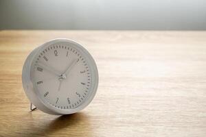 Silver alarm clock on wood table background photo