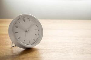 Silver alarm clock on wood table background photo