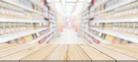 mesa de madera con fondo borroso de la tienda de comestibles del supermercado con luz bokeh para la exhibición del producto foto