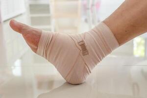 Man with ankle sprain elastic bandage for ankle injury and feeling pain photo